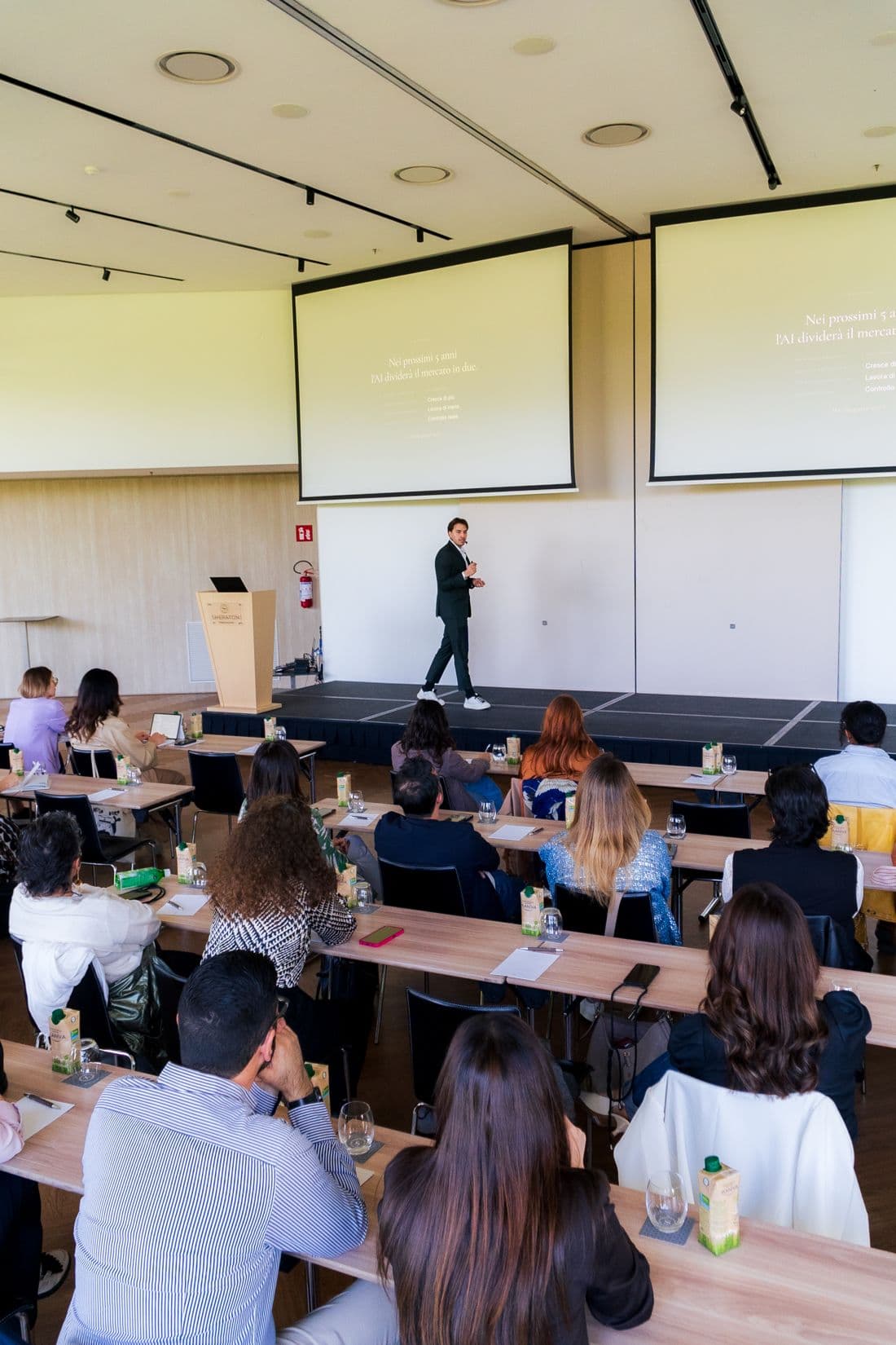 Michele Ignat sul palco davanti a una sala di architetti, interior designer e progettisti